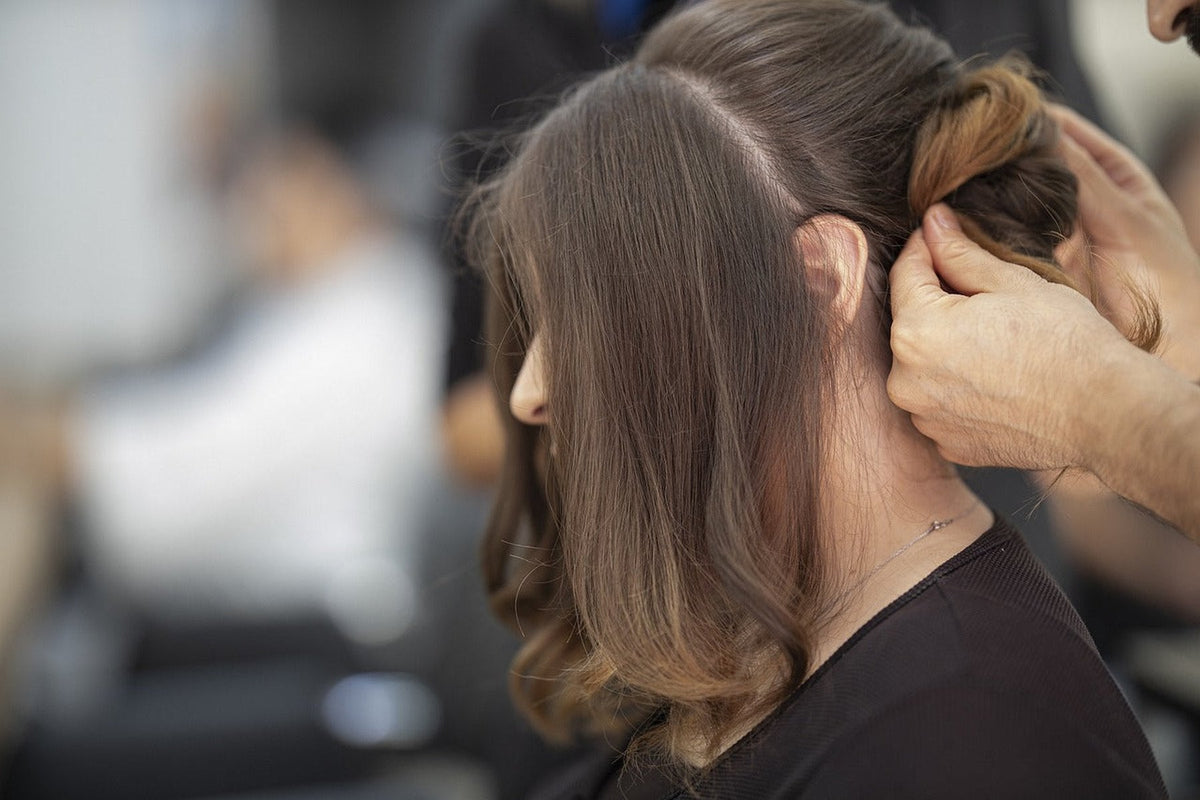 A hairdresser sectioning a client's hair